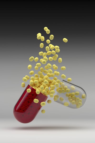 Studio shot of capsule with yellow pills inside