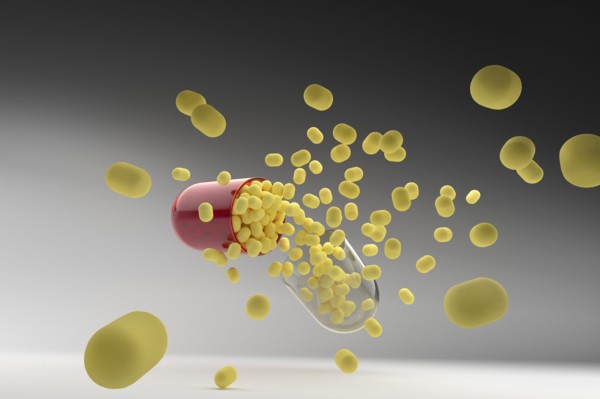 Studio shot of capsule with yellow pills inside