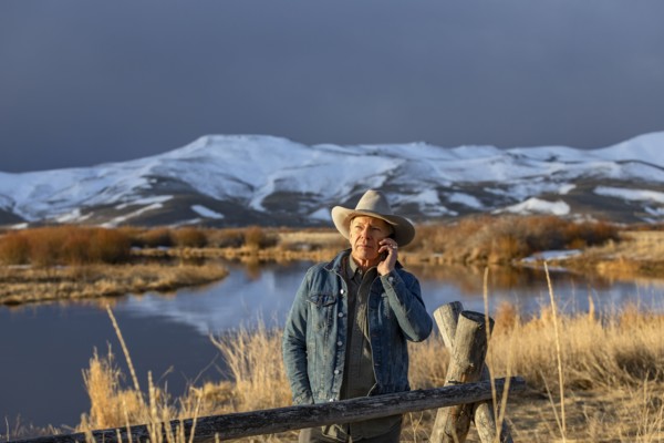 USA, Idaho, Sun Valley, Senior man in cowboy using smartphone