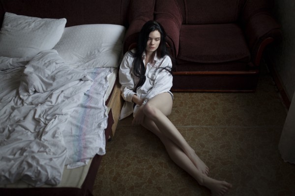 Semi-dress woman sitting on floor in bedroom