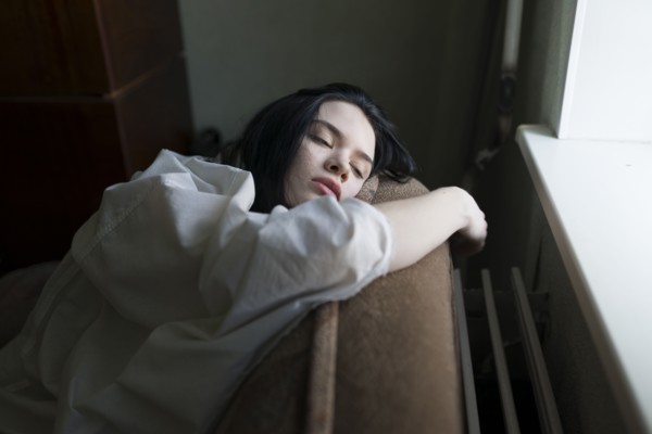 Young woman leaning by window