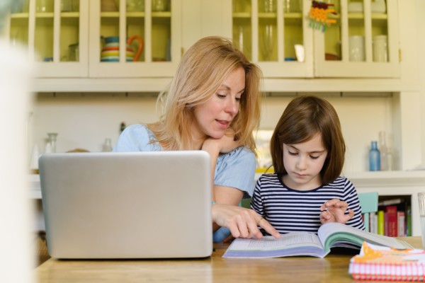 Mother helping daughter (6-7) doing homework