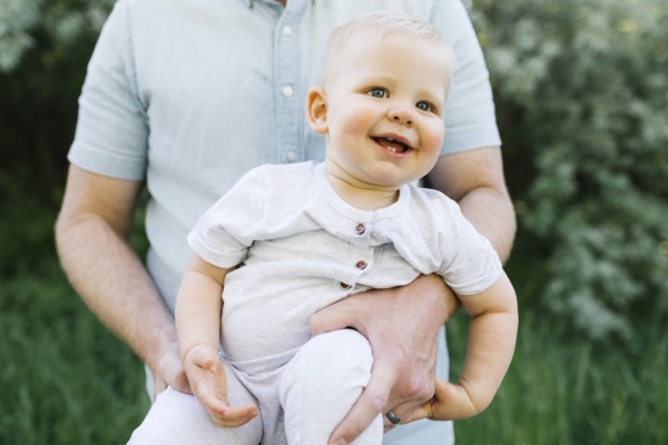 Outdoor portrait of baby boy carried by his father outdoors