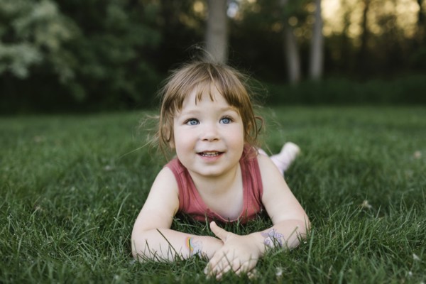 Girl (2-3) lying on grass