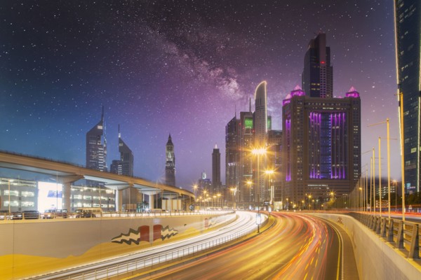 United Arab Emirates, Dubai, Traffic on highway and modern city architecture at dusk