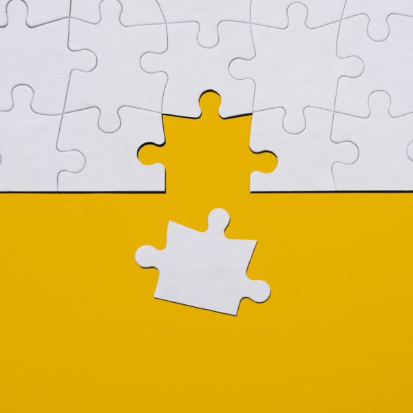 Last puzzle piece in jigsaw puzzle on yellow background