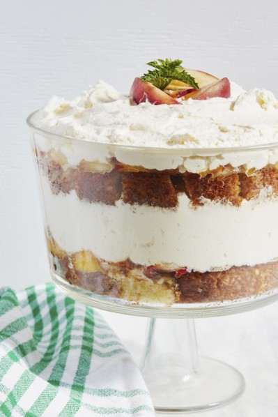 Trifle dessert with whipped cream and peaches