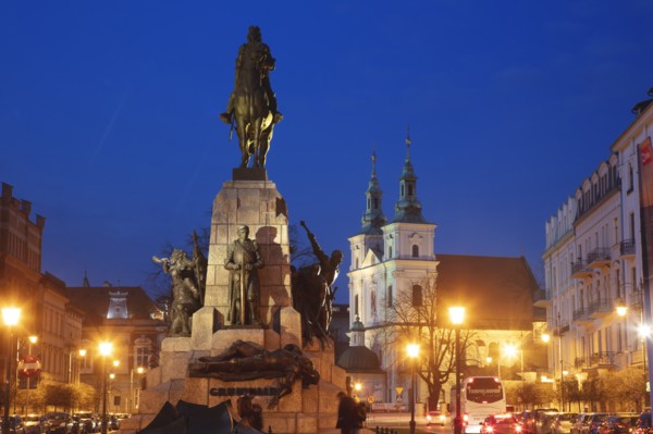 Poland, Lesser Poland, Krakow, Monument with statues on illuminated old town square