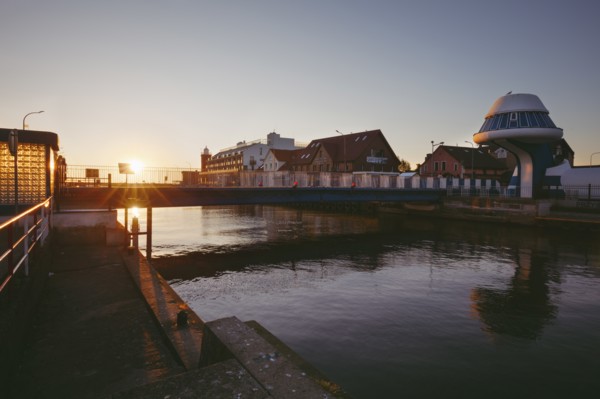 Poland, West Pomerania, Darlowek, Lighthouse and bridge over Wieprza River at sunset