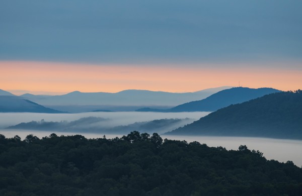 USA, Georgia, Fog above forest and Blue Ridge Mountains at sunrise