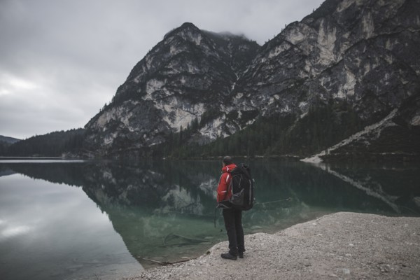 Italy, Pragser Wildsee, Dolomites, South Tyrol, Man looking at view standing near mountain lake
