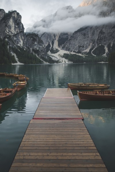 Italy, Pragser Wildsee, Dolomites, South Tyrol, Rowboats moored near jetty in mountain lake