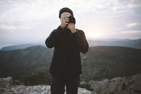 Italy, Liguria, La Spezia, Man using camera in mountains