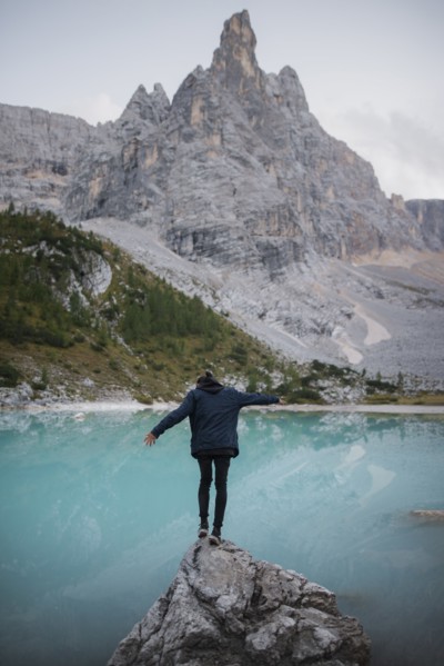 Italy, South Tyrol, Cortina d Ampezzo, lake Sorapis, Man standing on top of rock catching balance