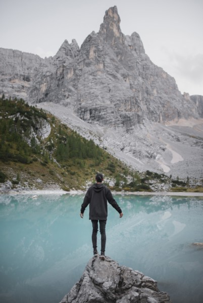 Italy, South Tyrol, Cortina d Ampezzo, lake Sorapis, Man standing on rock looking at lake