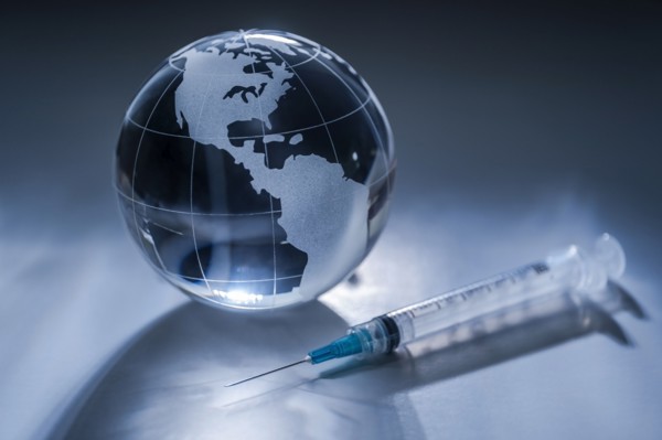 Glass globe and syringe on gray background