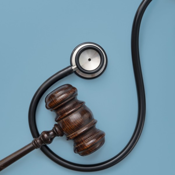 Gavel and stethoscope on blue background