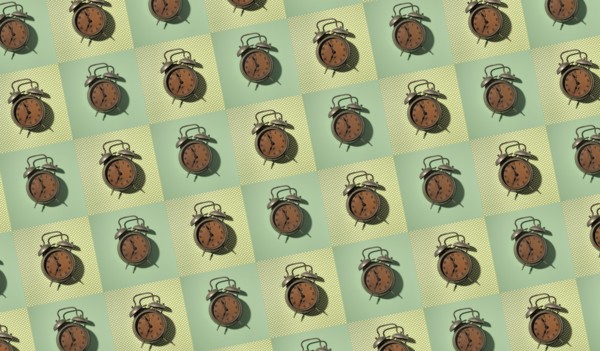 Rows of vintage alarm clocks on green background