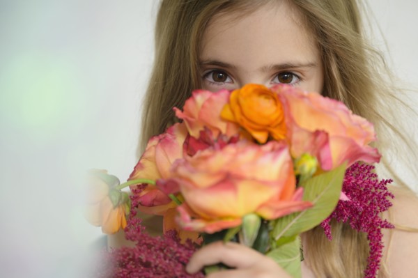 Girl (6-7) holding flower bouquet