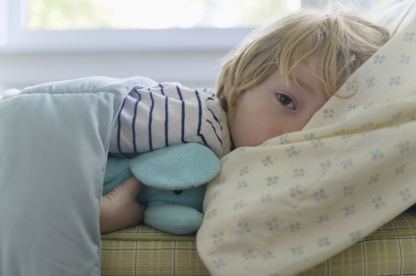 Boy (4-5) lying in bed