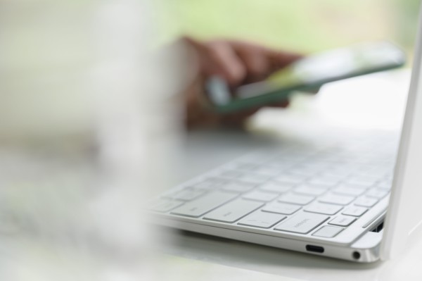 Woman's hands using laptop and smart phone