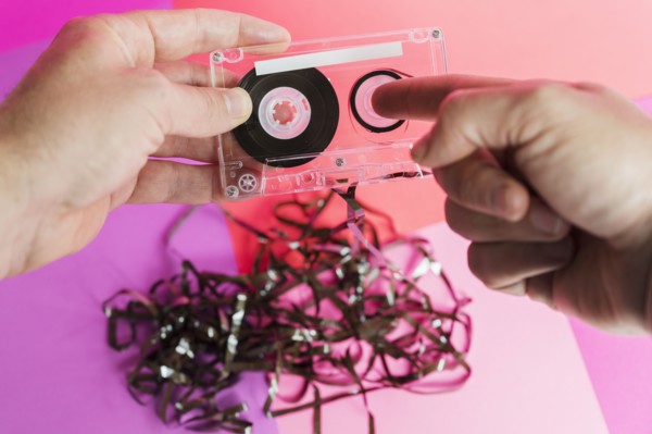 Hands holding damaged audio tape
