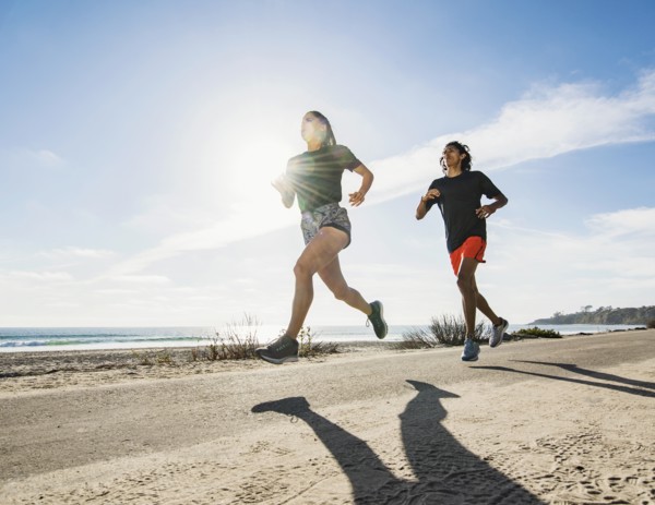 USA, California, Dana Point, Man and woman running together by coastline