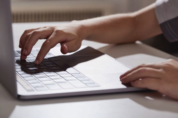 Close-up of boys (8-9) hands typing on laptop