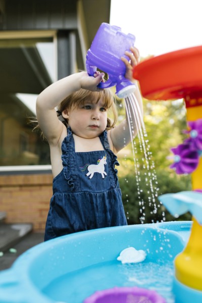 Toddler girl (2-3) playing with water in garden