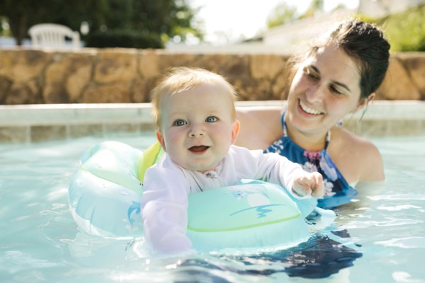 Mother with baby son (6-11months) playing in outdoor swimming pool