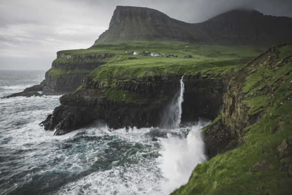Denmark, Faroe Islands, Gasadalur village, Mulafossur Waterfall, Mulafossur Waterfall falling from cliff into ocean