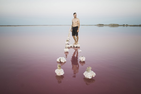 Ukraine, Crimea, Man standing on salt crystal in salt lake