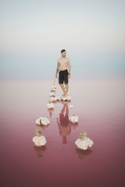 Ukraine, Crimea, Man standing on salt crystal in salt lake