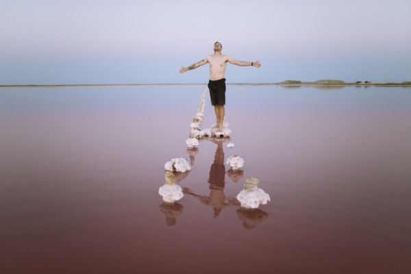 Ukraine, Crimea, Man standing on salt crystal in salt lake