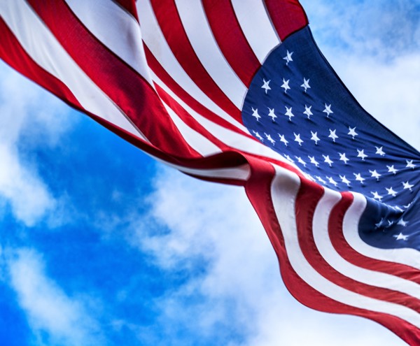 American flag blowing in wind against sky