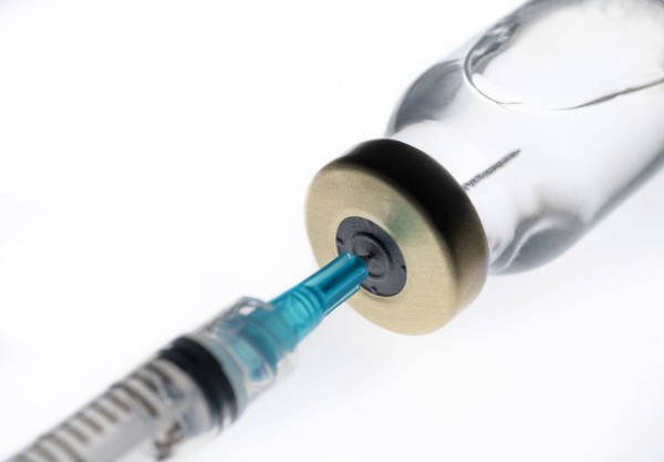 Studio shot of Covid-19 vaccine and syringe