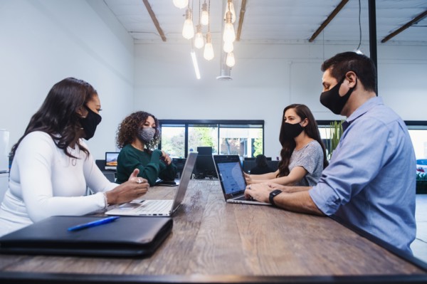 People in face masks having meeting in office
