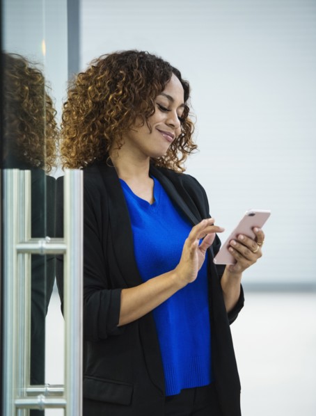 Smiling businesswoman using smart phone in office