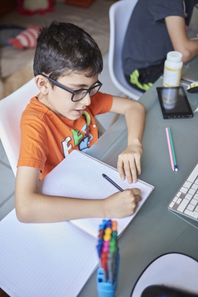 Two boys learning at desk at home during Covid-19 lockdown