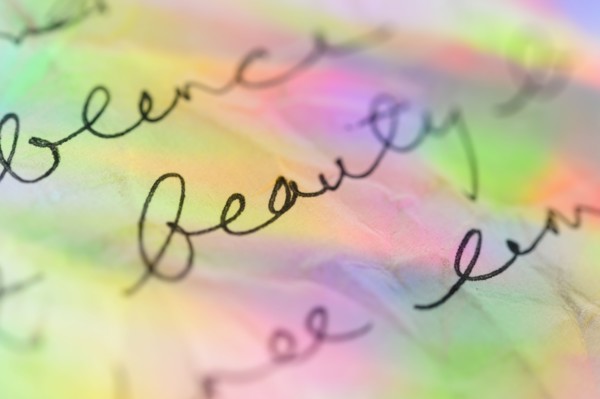 Handwriting on paper with colorful reflections