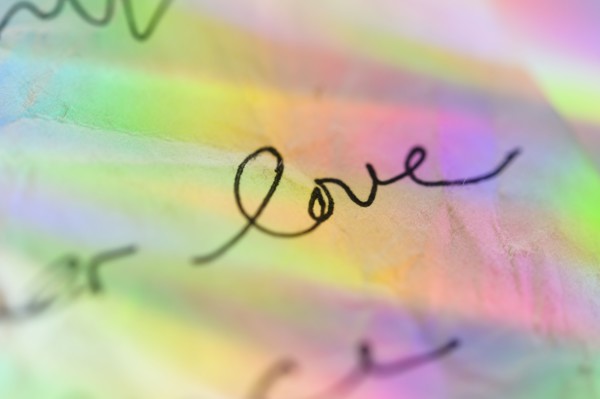 Handwriting on paper with colorful reflections