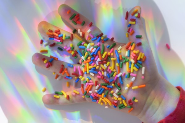 Hand holding sprinkles with colorful reflections