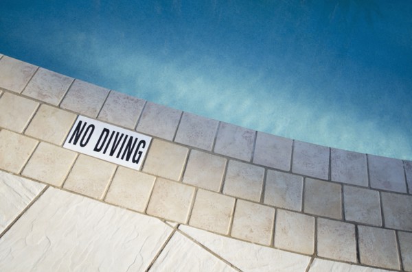 Warning sign at edge of swimming pool
