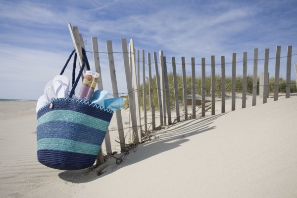 Beach bag with flip-flops on beach