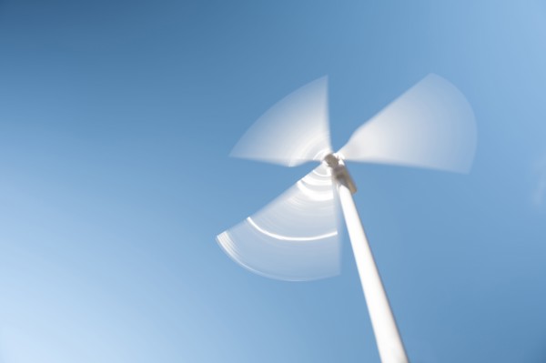 Low angle view of wind turbine against blue sky
