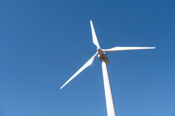 Low angle view of wind turbine against blue sky