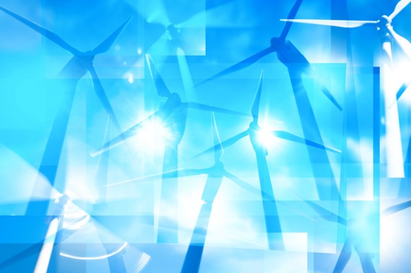 Silhouettes of wind turbines against blue sky