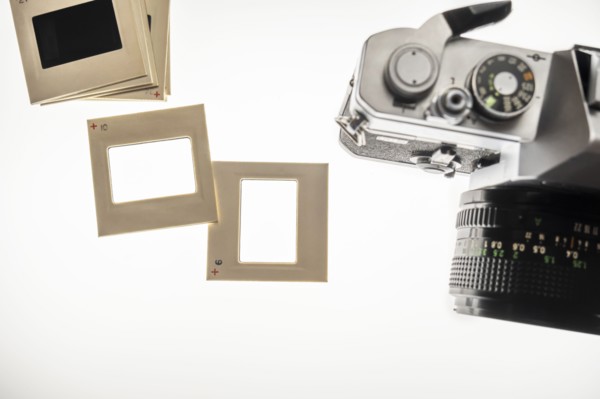 Studio shot of blank slide film transparencies on lightbox and 35mm camera