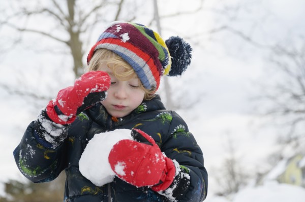 Boy (6-7) holding snowball