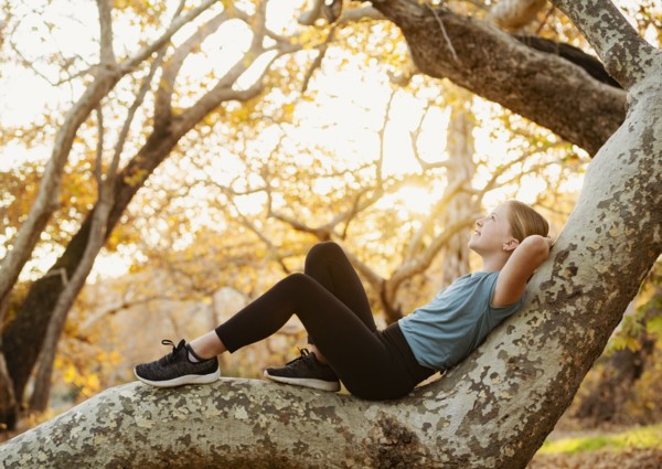 Girl relaxing on tree branch